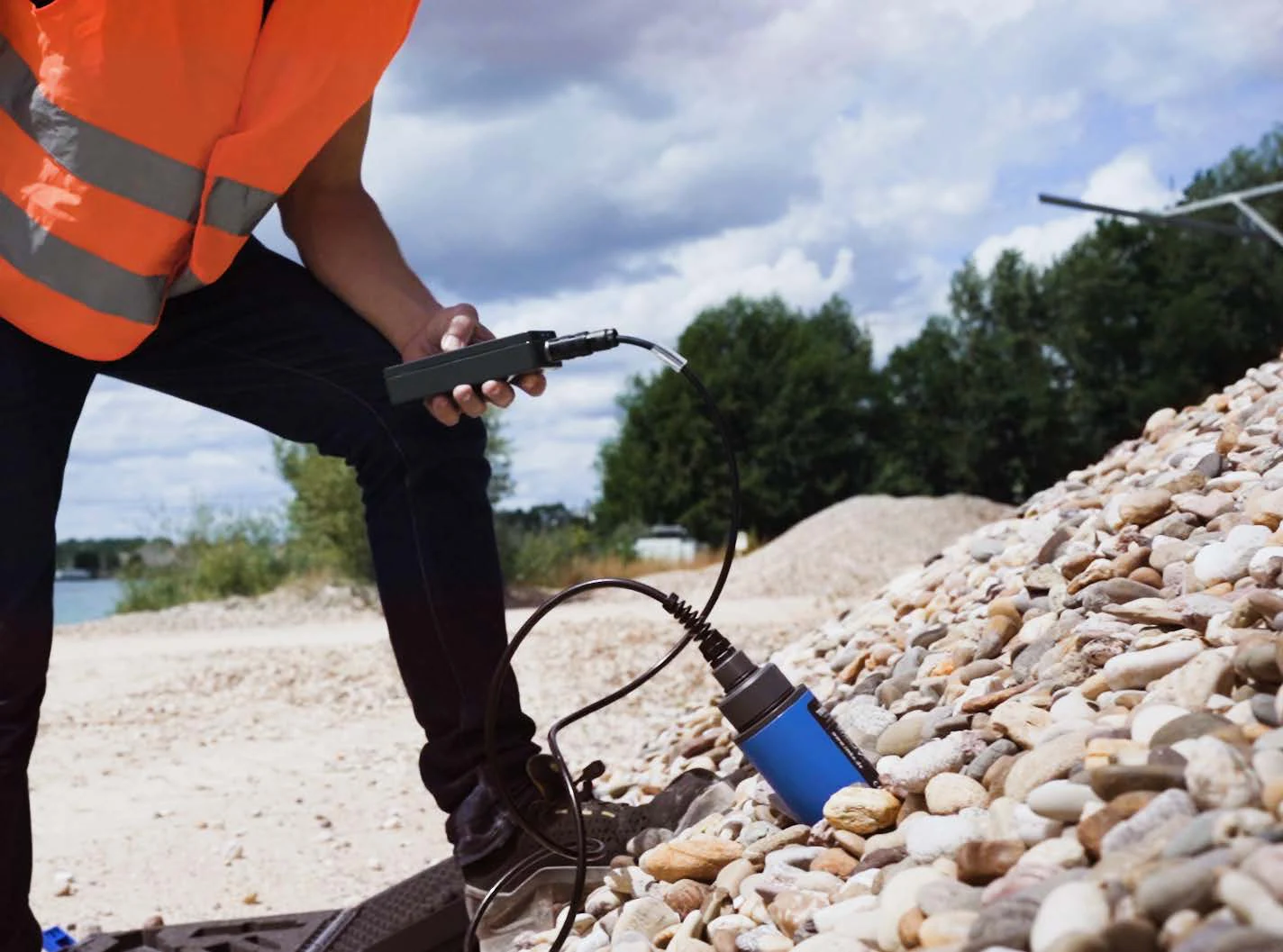 Portable TDR meter and probe taking a moisture reading in aggregate
