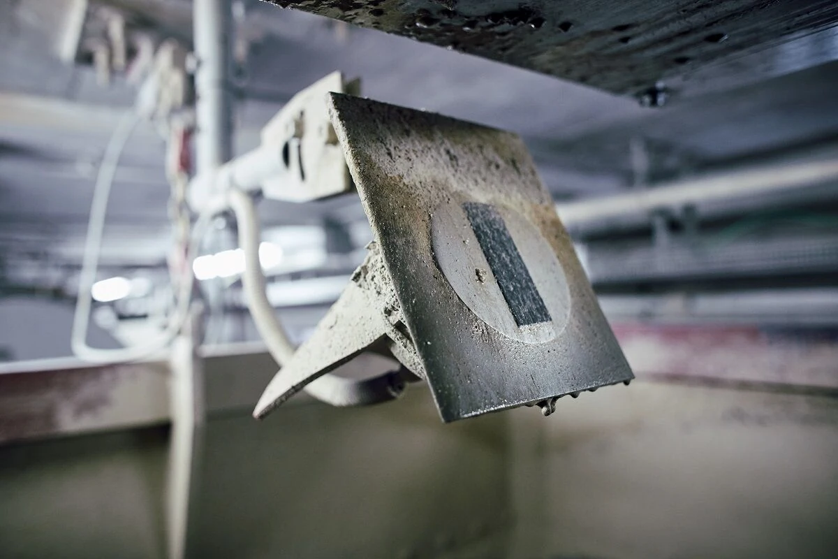 Carried on an adjustable arm at a bin discharge